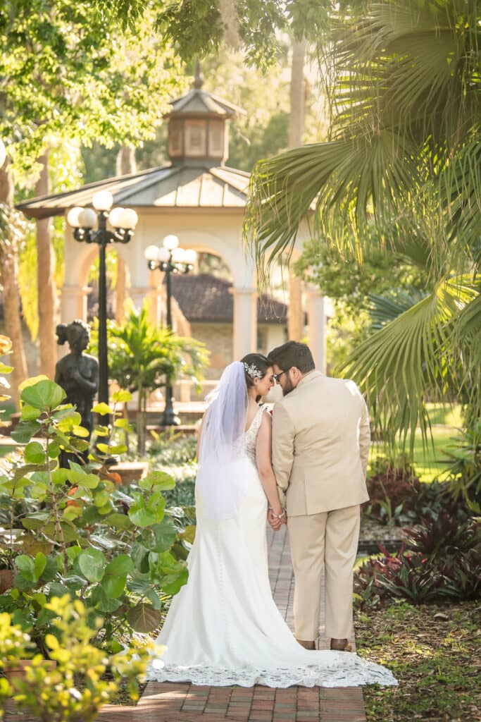 Bride and groom on a garden path beside the lakeside Gazebo