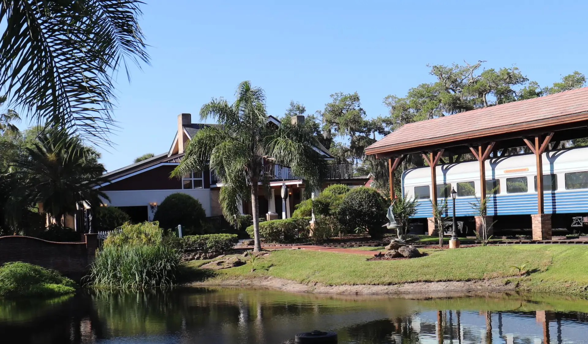 The historic blue Club Car and The Tavern surrounded by palms and estate gardens